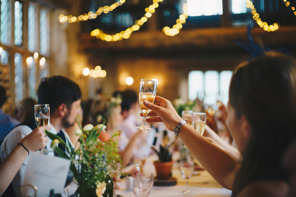 Guests raise a glass to toast at an upscale indoor wedding